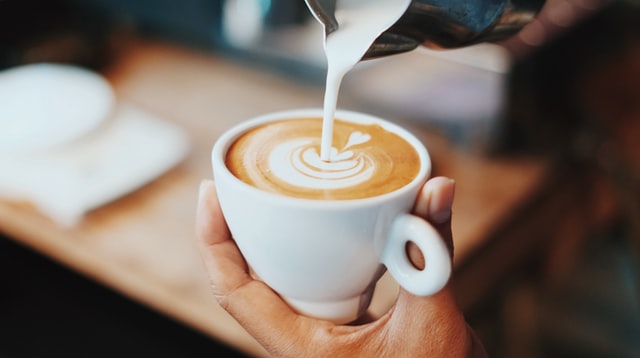 pouring milk into a coffee cup