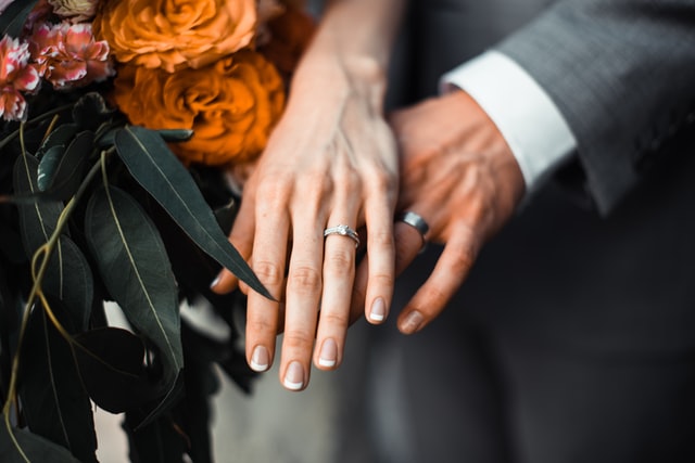 man and woman's hands with wedding rings