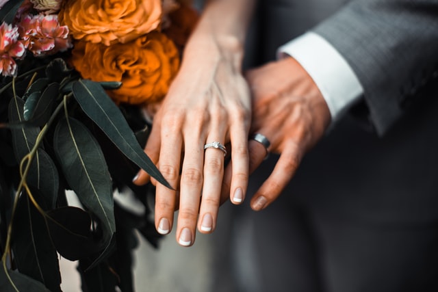 The Ultimate Guide to Wedding Planning on a Budget 1 man and woman's hands with wedding rings
