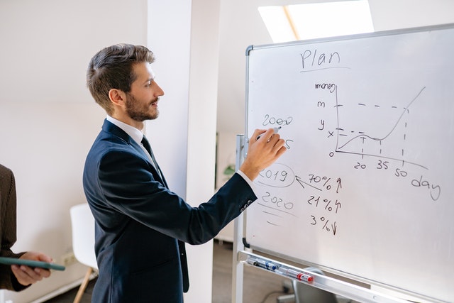 man writing on a board