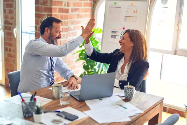 man and woman hi-five at a table