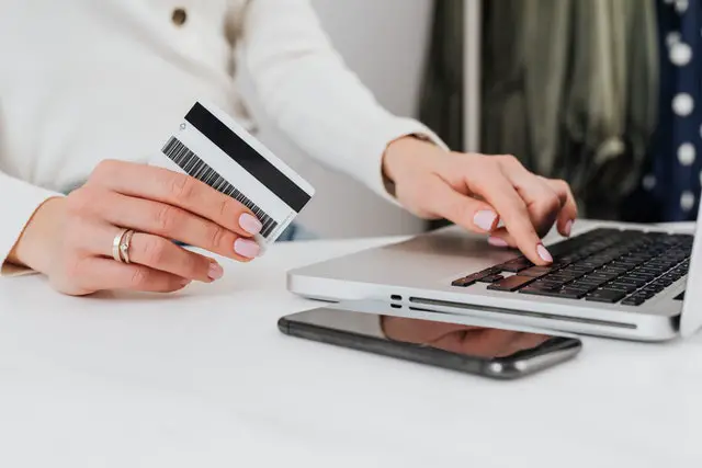 Female holding credit card and using a laptop