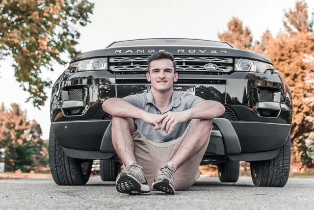 man sitting in front of a car