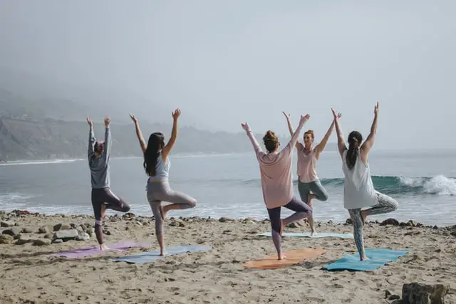 women doing yoga at the beach