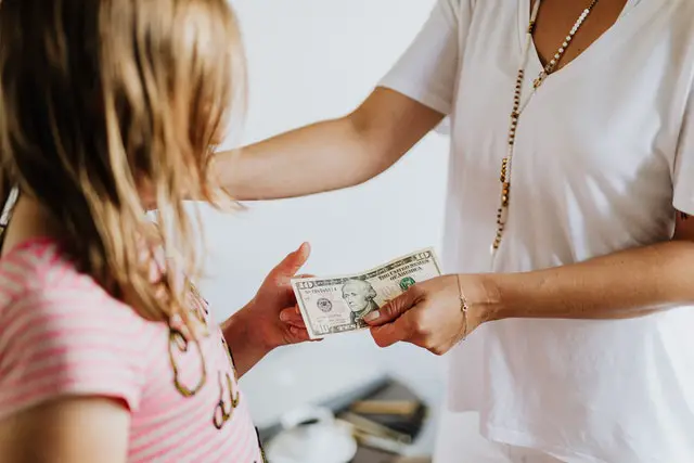 Adult giving money to a child
