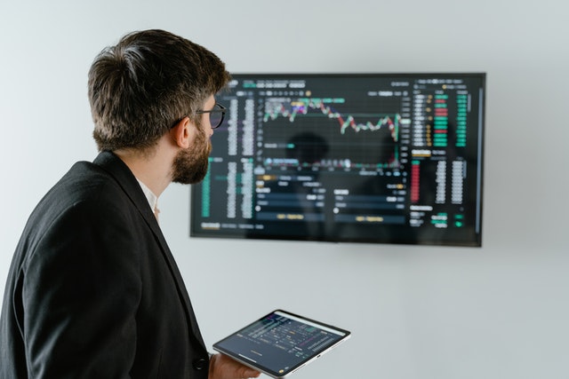 man looking at a stock market monitor