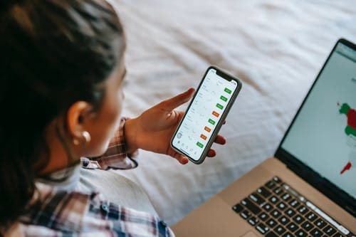 6 Signs Your Stock Broker Is Up To No Good 3 woman holding a phone in front of a laptop