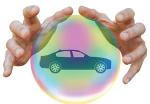 hands around a bubble with a car inside