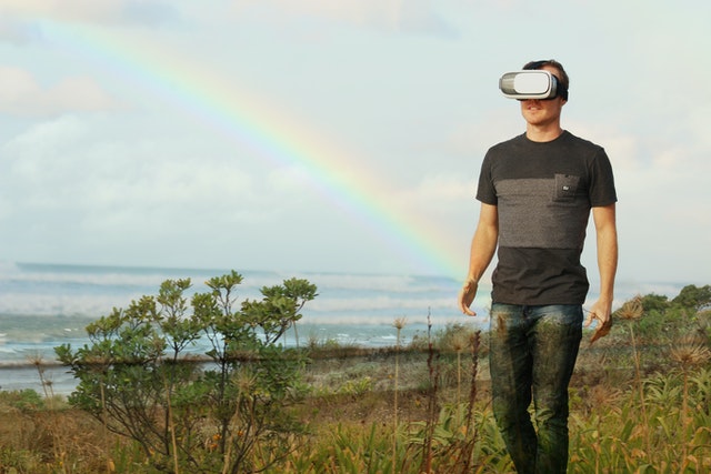 man wearing virtual reality goggles walking in nature