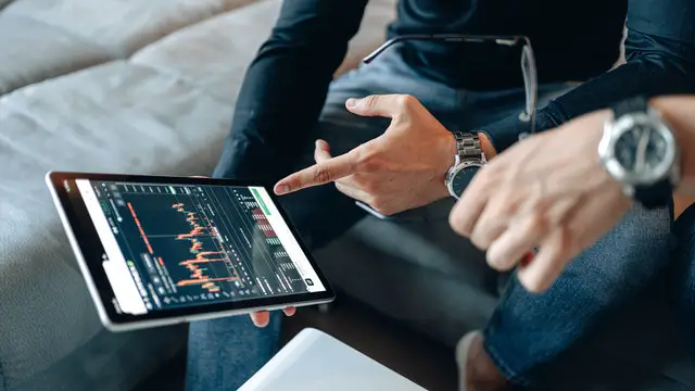 person holding and pointing at a digital screen