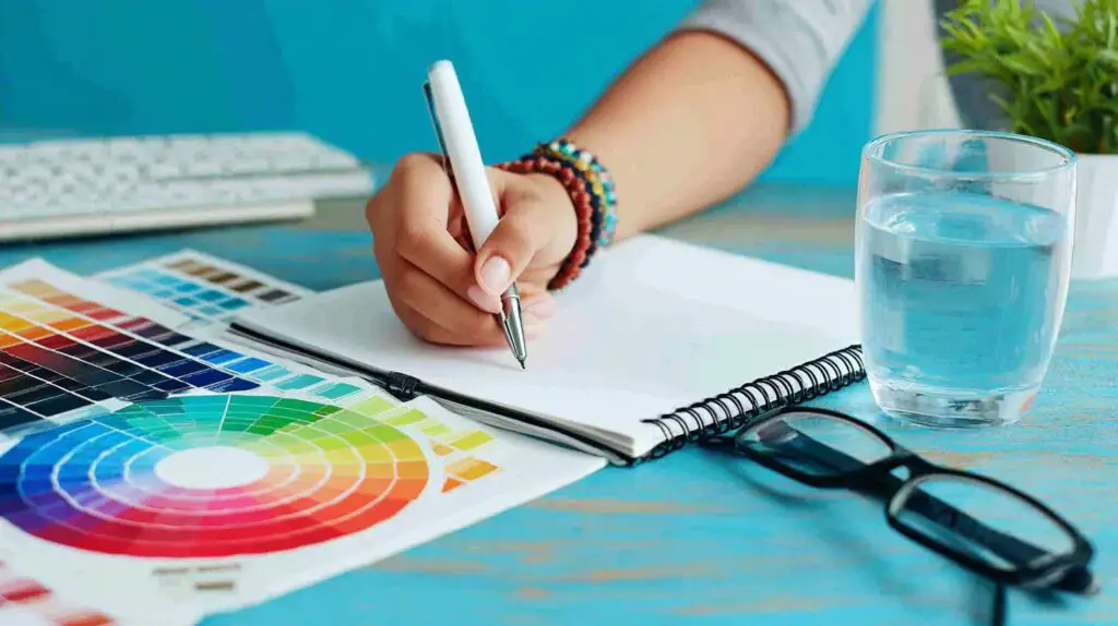 A person's hands using a stylus on a digital tablet with design software, illustrating graphic design work.